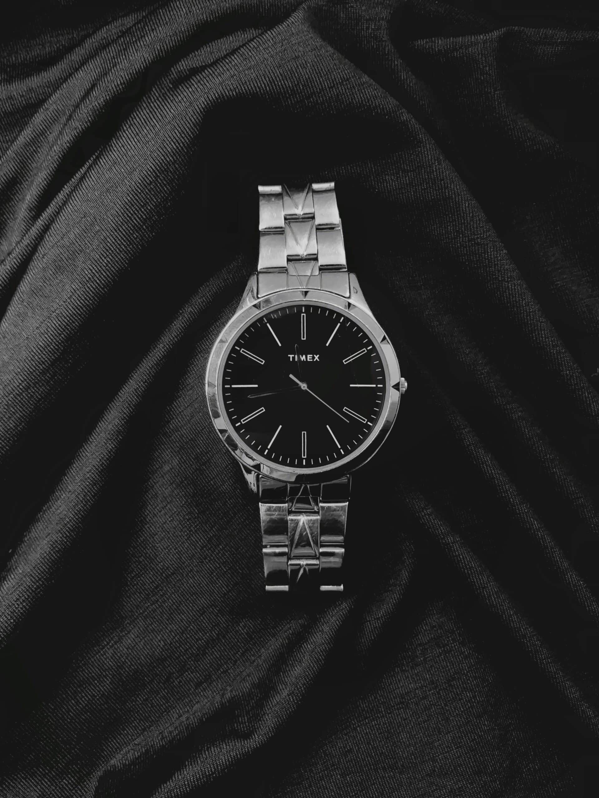a watch sitting on top of a black cloth
